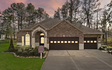 A house with a driveway and a sign in front of it.