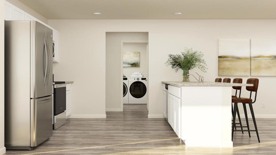 A kitchen with a table and chairs.