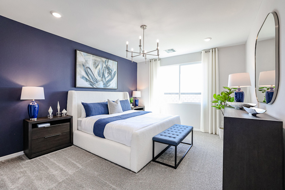 A bedroom with a bed and a bench.