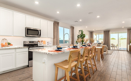 A kitchen with a dining table and chairs.
